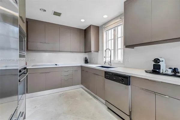 a kitchen with a sink cabinets appliances and a window