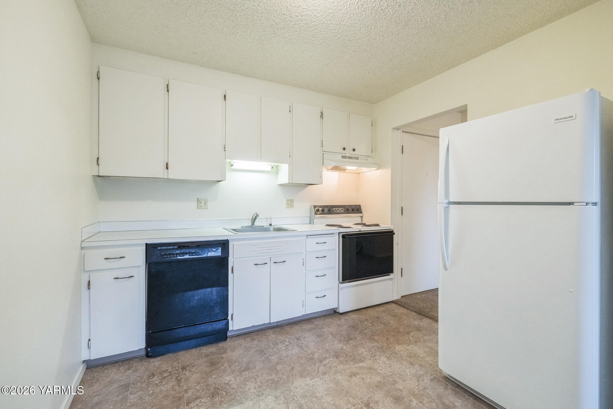1020 South 20th Avenue Yakima, WA 98902 - Photo 9 of 18 a kitchen with a refrigerator stove and white cabinets