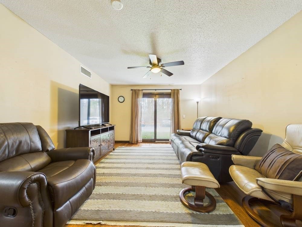 1940 Phillips Road, Unit 17 New Bedford, MA 02745 - Photo 6 of 18 a living room with furniture ceiling fan and a rug