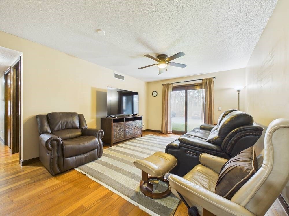 1940 Phillips Road, Unit 17 New Bedford, MA 02745 - Photo 7 of 18 a living room with furniture ceiling fan and a wooden floor