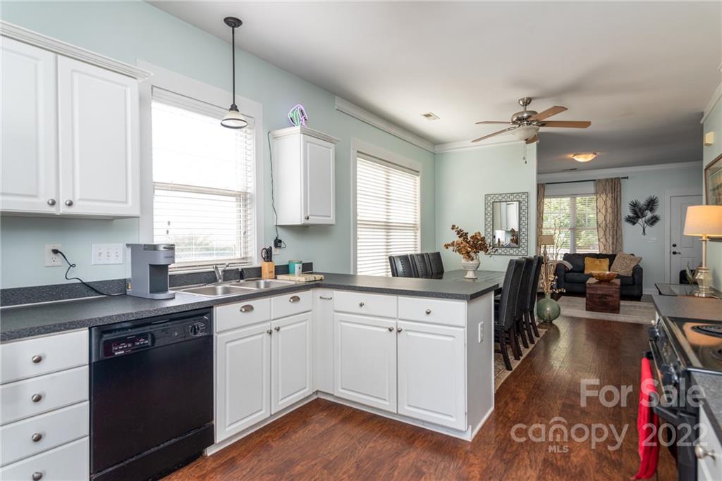 8110 Strandhill Road Huntersville, NC 28078 - Photo 12 of 23 a kitchen with a sink dishwasher a stove and white cabinets with wooden floor