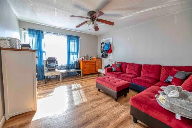 a living room with furniture and a wooden floor