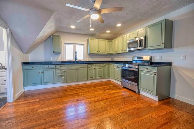 a large kitchen with wooden floors and stainless steel appliances