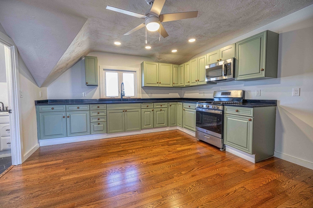 1273-1279 South Main Street Fall River, MA 02724 - Photo 5 of 33 a large kitchen with wooden floors and stainless steel appliances