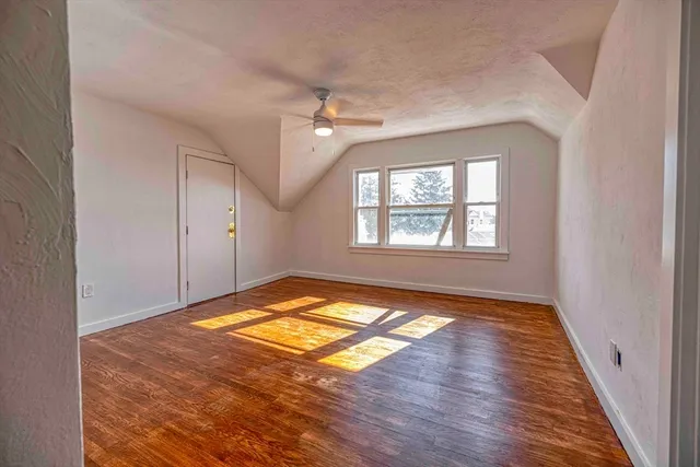a view of empty room with window and wooden floor