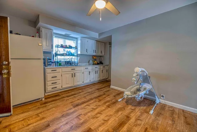 a kitchen with granite countertop a refrigerator a sink a stove a dining table and chairs