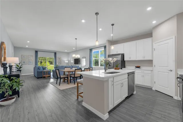 a kitchen with a dining table chairs stove refrigerator and cabinets