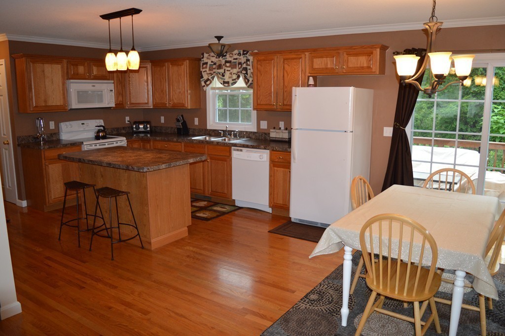 83 Stuart Street Springfield, MA 01119 - Photo 7 of 17 a kitchen with refrigerator a stove a sink and a dining table with garden view