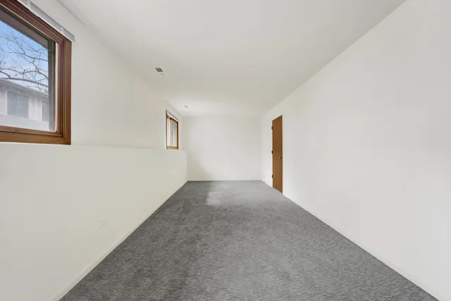 a view of a big room with windows and chandelier fan
