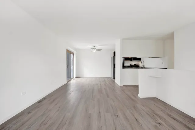 a view of a kitchen with wooden floor and electronic appliances