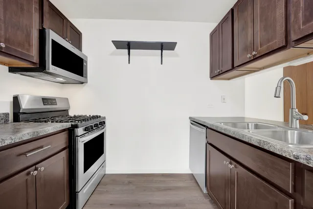 a kitchen with stainless steel appliances granite countertop a sink stove and microwave