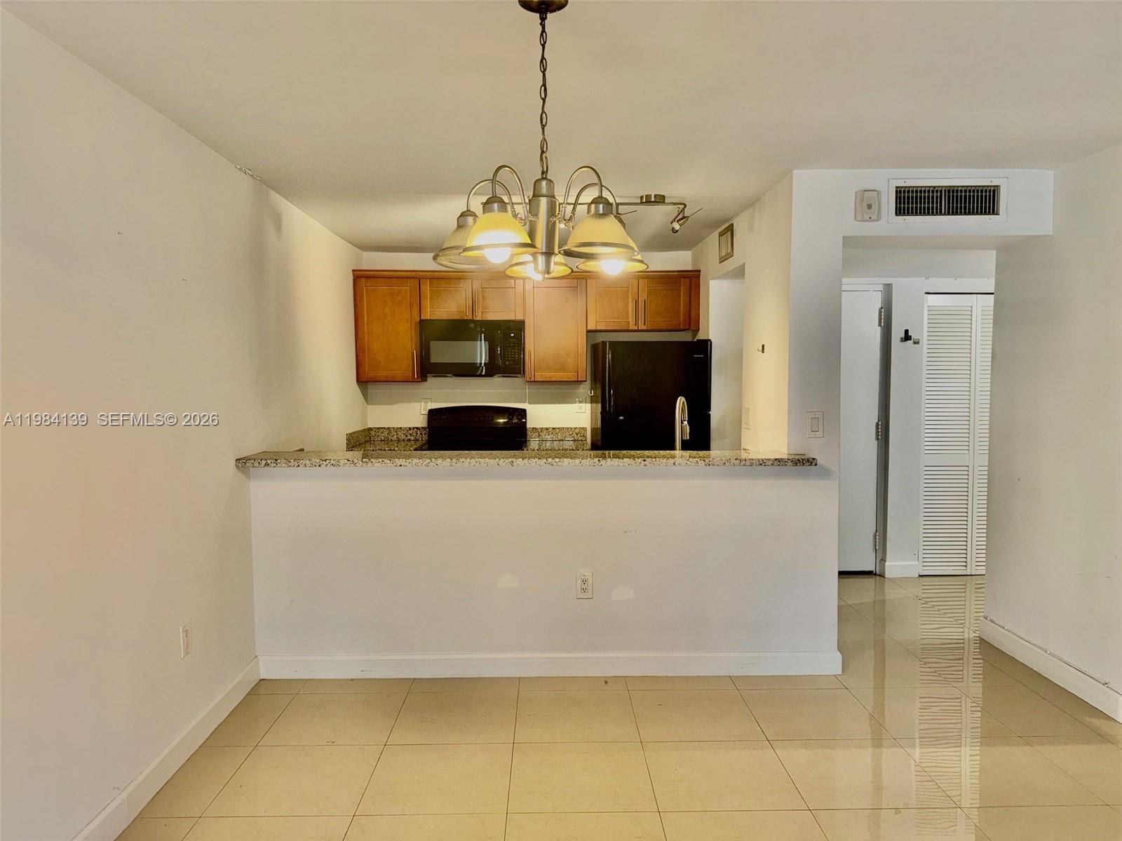 10700 Southwest 108th Avenue, Unit C209 Miami, FL 33176 - Photo 1 of 18 a living room with fireplace furniture and a chandelier