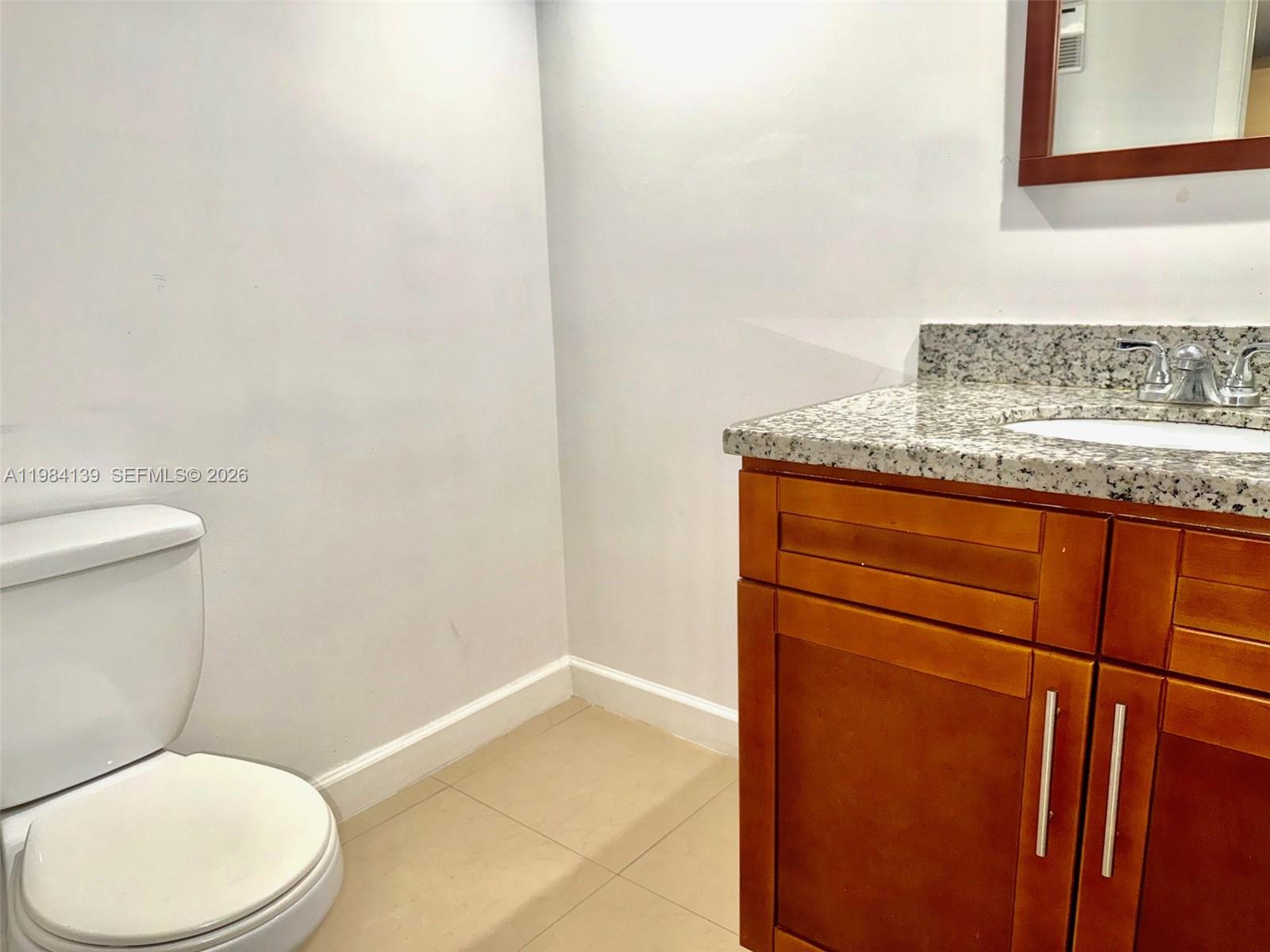 10700 Southwest 108th Avenue, Unit C209 Miami, FL 33176 - Photo 11 of 18 a bathroom with a granite countertop toilet and a sink