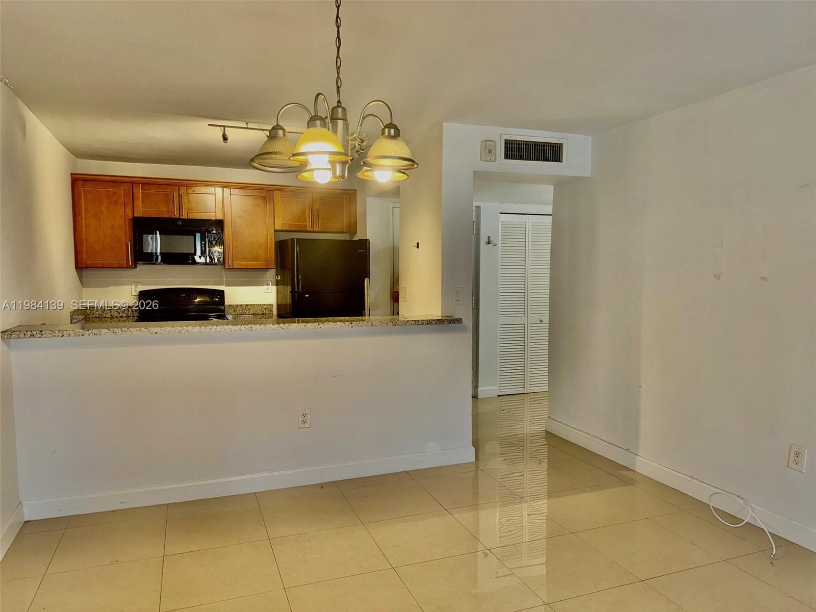 10700 Southwest 108th Avenue, Unit C209 Miami, FL 33176 - Photo 2 of 18 a view of a kitchen with cabinets and stainless steel appliances