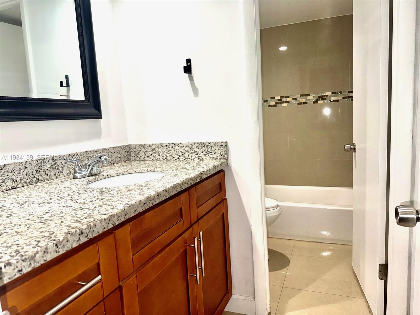 10700 Southwest 108th Avenue, Unit C209 Miami, FL 33176 - Photo 7 of 18 a bathroom with a granite countertop sink and a mirror