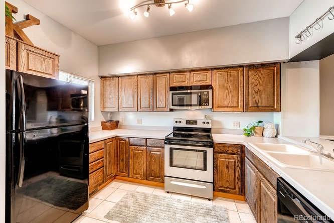 206 South Oman Road Castle Rock, CO 80104 - Photo 10 of 25 a kitchen with stainless steel appliances a stove sink microwave and cabinets