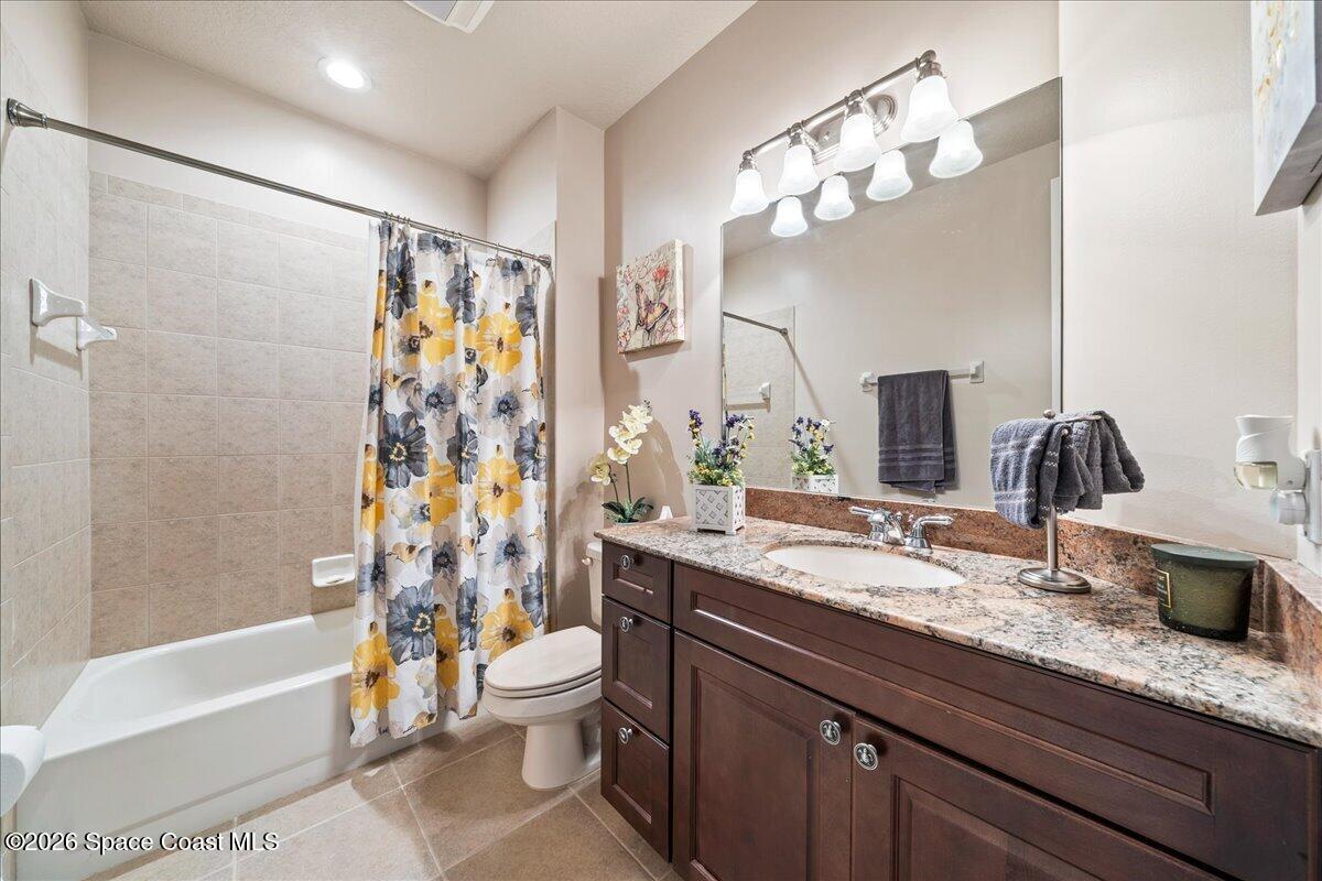 6005 Highway 1, Unit 101 Rockledge, FL 32955 - Photo 24 of 57 a bathroom with a granite countertop sink a toilet a mirror a bathtub and shower