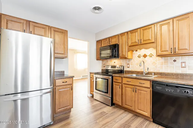 a kitchen with stainless steel appliances granite countertop a refrigerator stove microwave and sink