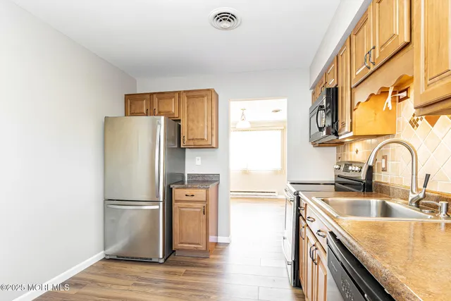 a kitchen with granite countertop a refrigerator and a sink