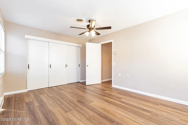 an empty room with fan and windows