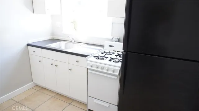 a kitchen with granite countertop cabinets and refrigerator