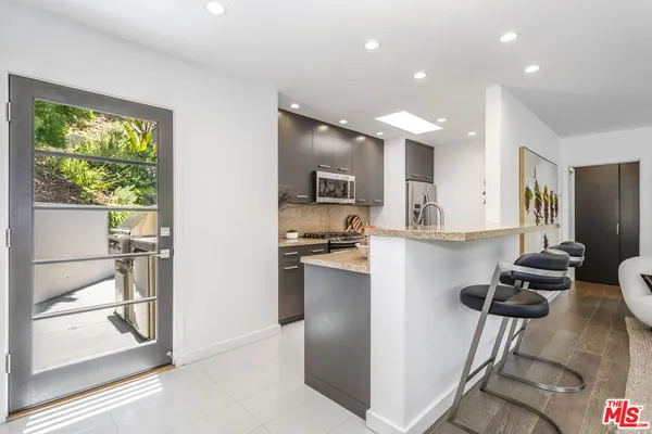 a kitchen with a refrigerator and a stove top oven