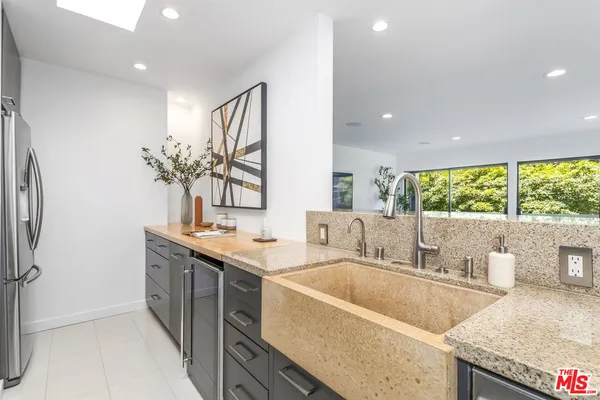 a bathroom with a granite countertop sink and a large mirror