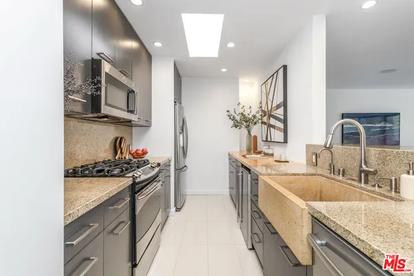 a kitchen with stainless steel appliances granite countertop a sink stove and cabinets