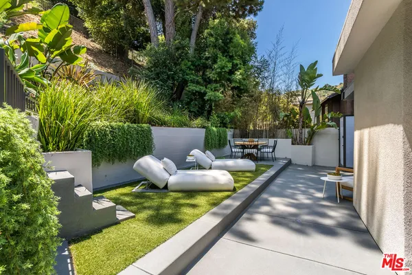 a view of a chairs and table in backyard
