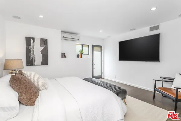 a bedroom with a bed and a flat screen tv