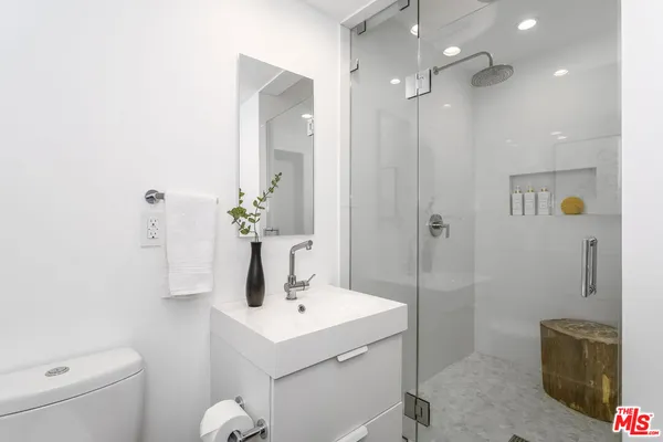 a bathroom with a sink a toilet and shower