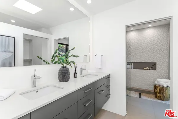 a bathroom with a double vanity sink and a mirror