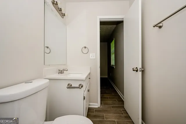 a bathroom with a sink a toilet a mirror and vanity