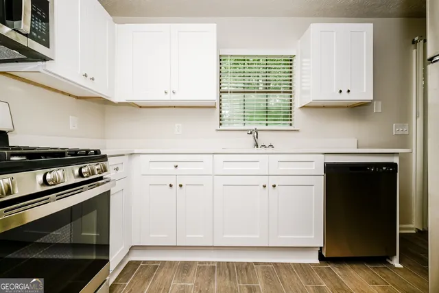 a kitchen with white cabinets and a stove