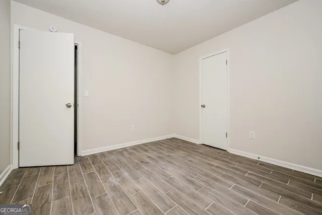 a view of an empty room with wooden floor