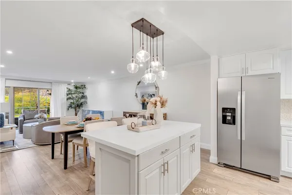 a kitchen with a sink a refrigerator and chairs