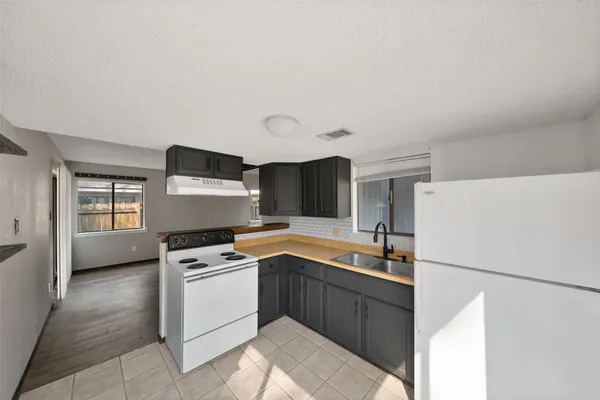 a kitchen with a stove a refrigerator and a sink