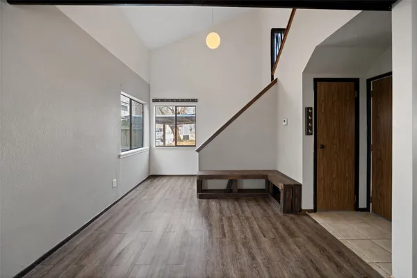 a view of a livingroom with wooden floor and stairs