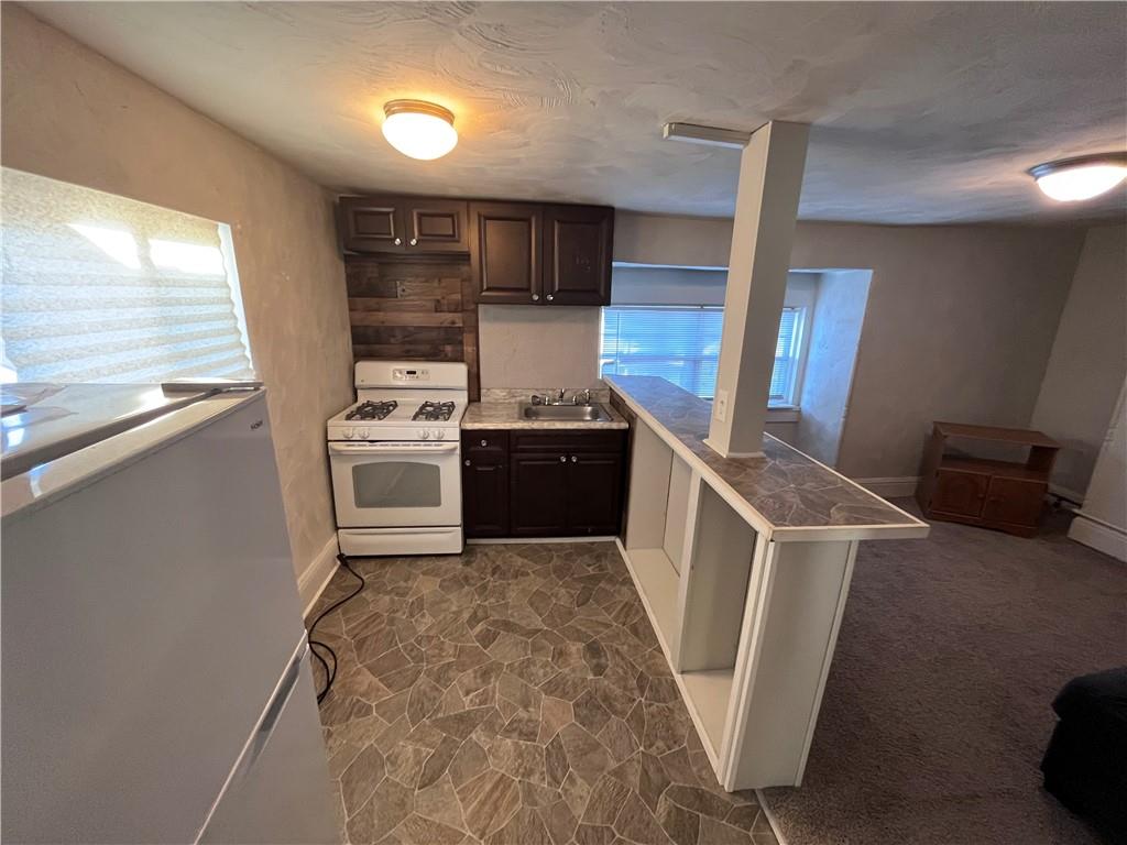 725 Clarissa Street Pittsburgh, PA 15219 - Photo 12 of 17 a kitchen with stainless steel appliances granite countertop a stove a sink and a refrigerator