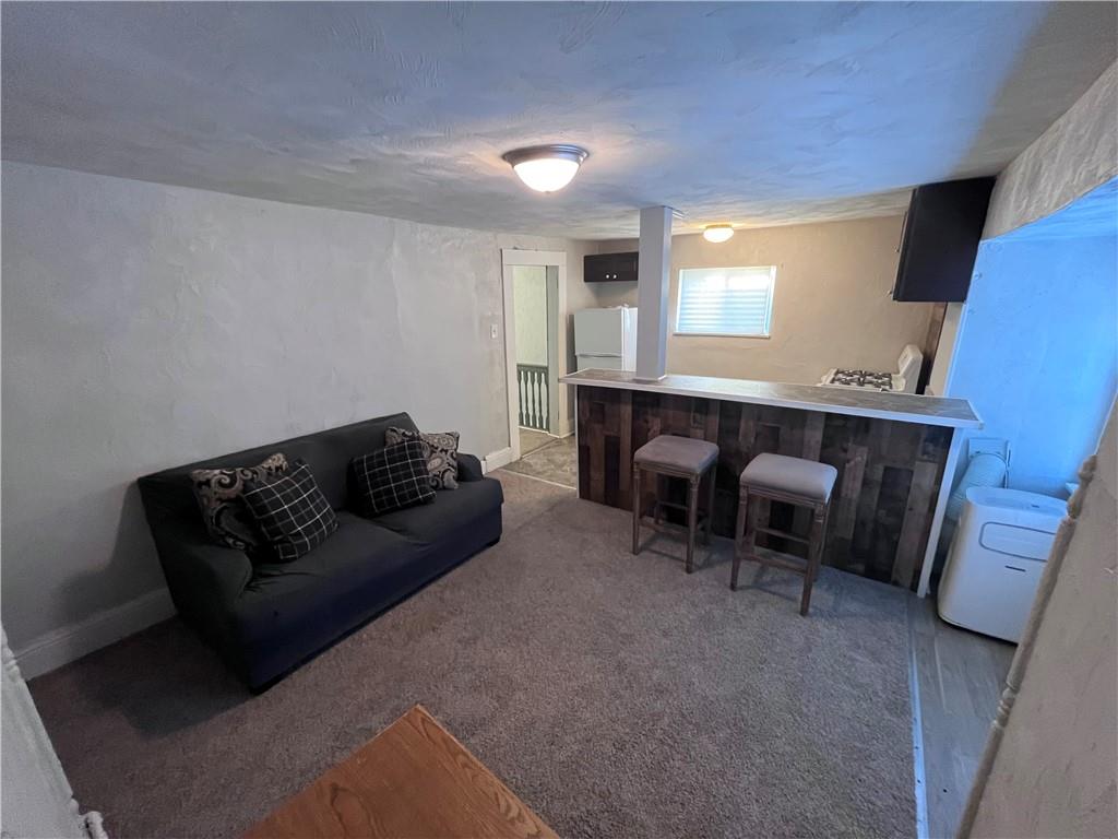 725 Clarissa Street Pittsburgh, PA 15219 - Photo 15 of 17 a living room with furniture and a fireplace