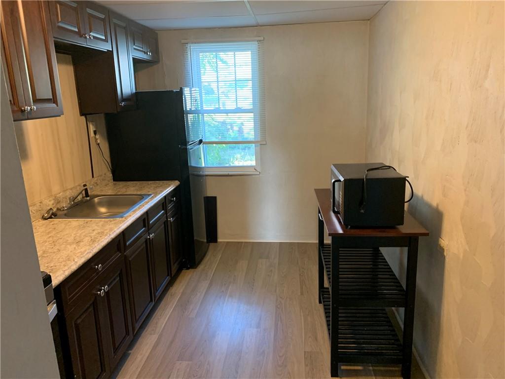 725 Clarissa Street Pittsburgh, PA 15219 - Photo 9 of 17 a kitchen with granite countertop a refrigerator a stove top oven and a counter space