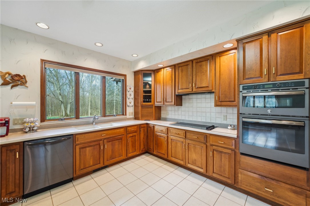 43301 Parsons Road Oberlin, OH 44074 - Photo 11 of 47 Kitchen with double wall oven, dishwasher, a sink, brown cabinets, and black electric cooktop
