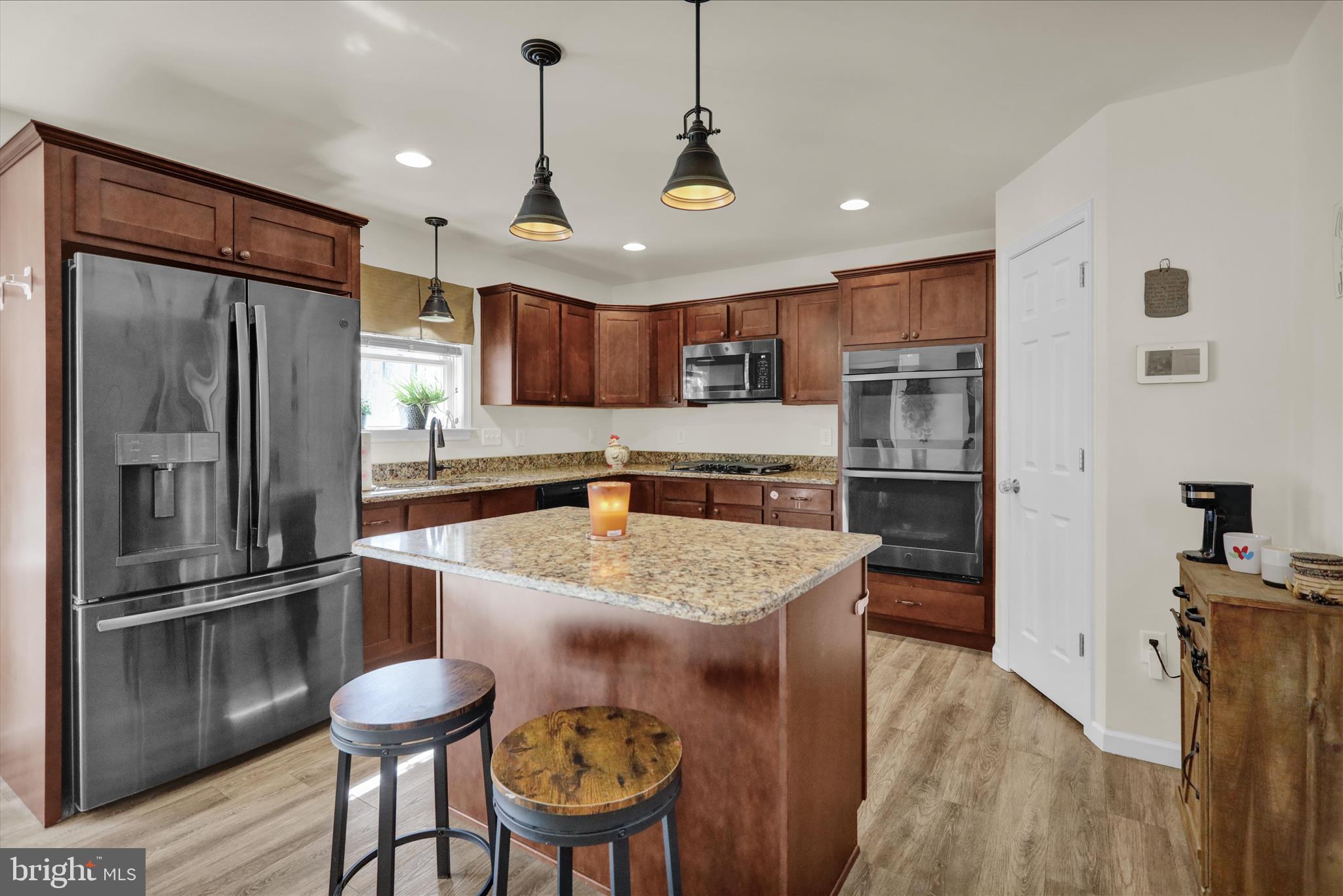 402 Mountainside Road Temple, PA 19560 - Photo 23 of 75 a kitchen with stainless steel appliances granite countertop a refrigerator a sink a stove a microwave oven a sink with island and chairs