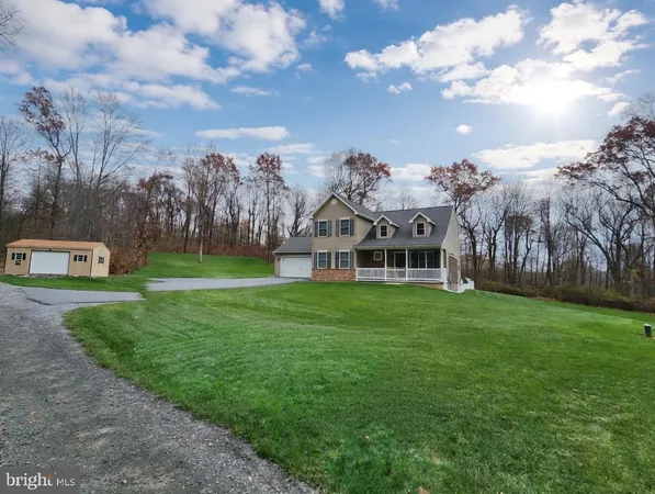 a view of a house with a big yard and large trees