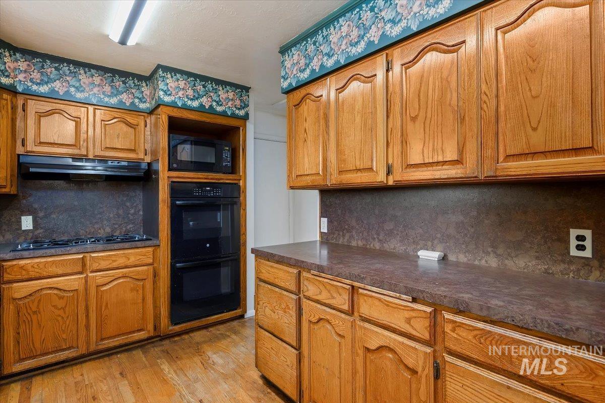 305 Lucille Street Kimberly, ID 83341 - Photo 13 of 36 Kitchen featuring tasteful backsplash, brown cabinets, and black appliances