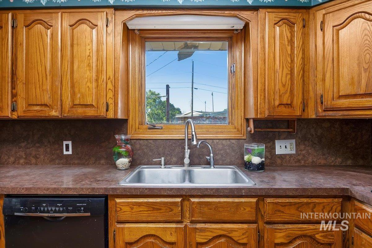305 Lucille Street Kimberly, ID 83341 - Photo 15 of 36 Kitchen with dishwasher, dark countertops, brown cabinets, and backsplash