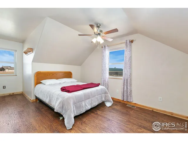a bedroom with a bed and a ceiling fan