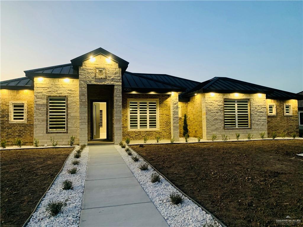 View of front of house featuring Stone, Brick Combination, Professional Landscaping and Metal Roof.