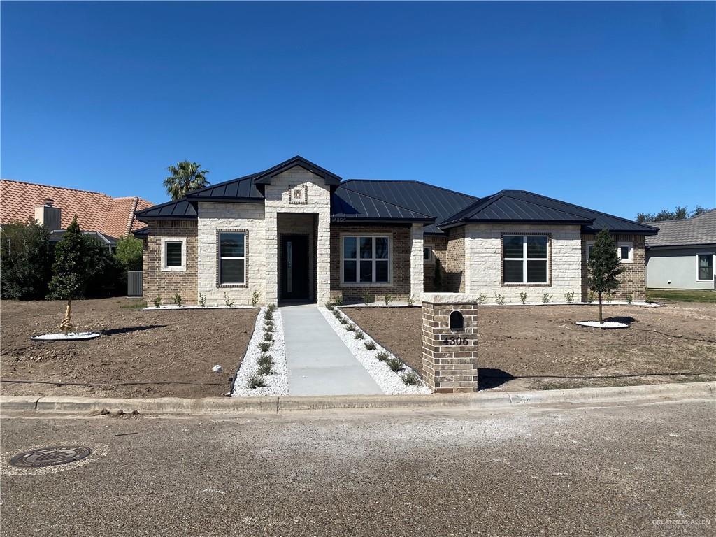 4306 Vida Santa Weslaco, TX 78596 - Photo 2 of 5 View of front of house featuring Stone, Brick Combination, Professional Landscaping and Metal Roof.