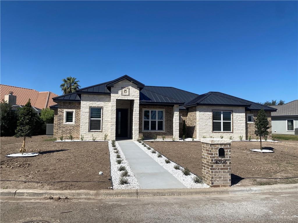 4306 Vida Santa Weslaco, TX 78596 - Photo 4 of 5 View of front of house featuring Stone, Brick Combination, Professional Landscaping and Metal Roof.